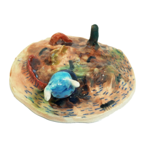 A Picture Of A Colourful Ceramic Piece Featuring A Bright Blue Creature Emerging From An Earth-toned Base.