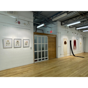An Interior Shot Of The Riverdale Gallery. It Features Two White Walls Each With Art Mounted On Them.