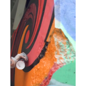 A Close Up Shot Of Flips Spray Painting A Swirl On A Wall.