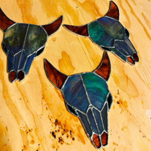 A Photo Of Three Stained Glass Cow Skulls.