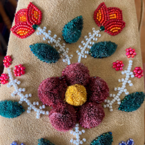 A Photo Of Beadworked And Felted Flowers On A Piece Of Leather.