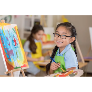 A Child Is Sitting At An Easel Holding A Paint Palette.